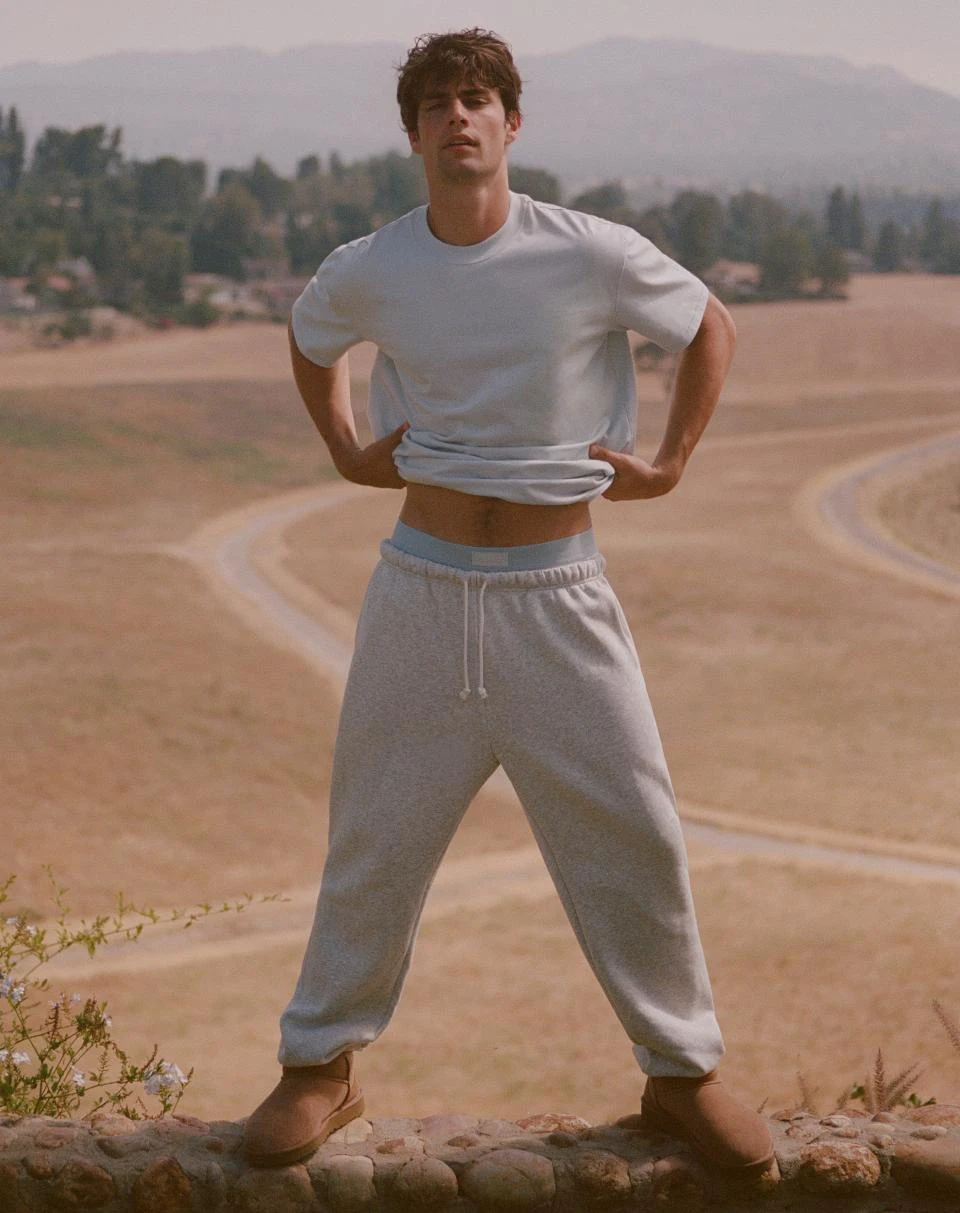 A MODEL POSES WEARING SKIMS MENS SPORT