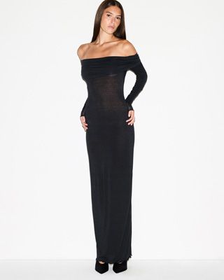 A MODEL POSES WEARING SKIMS DRESSES