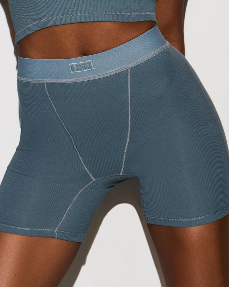 A MODEL POSES WEARING SKIMS BOXERS