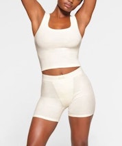 A model poses wearing SKIMS COTTON RIB TANK and BOXER SET