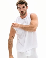 A MODEL POSES WEARING SKIMS MENS STRETCH T-SHIRT