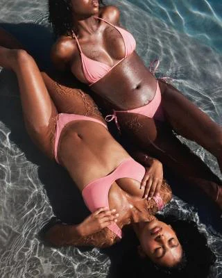 A MODEL POSES WEARING SKIMS TWO PIECE BIKINIS