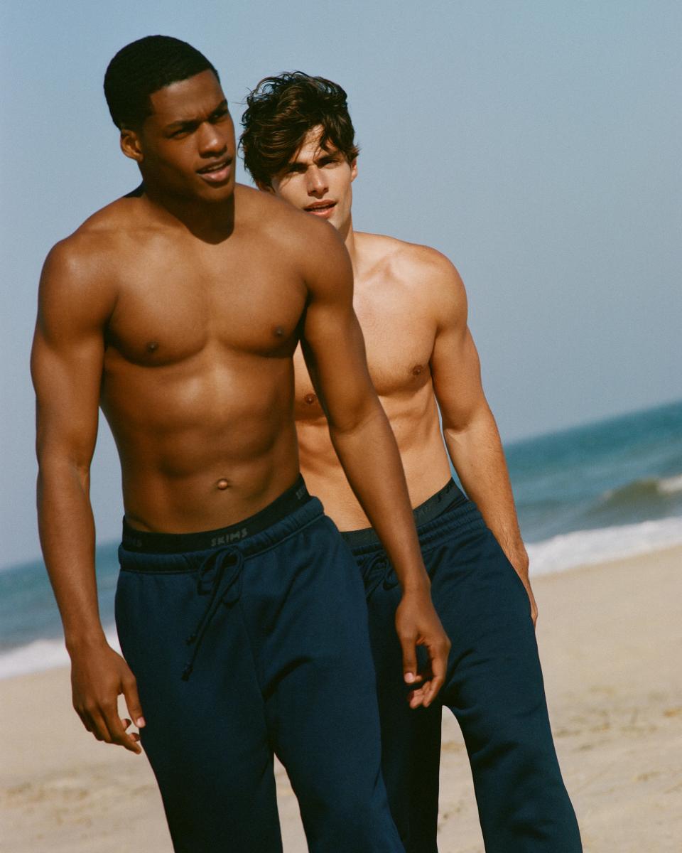 A MODEL POSES WEARING SKIMS MENS SPORT
