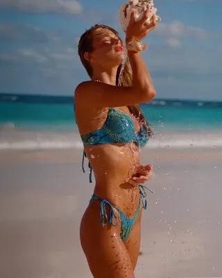 A MODEL POSES WEARING SKIMS TWO PIECE BIKINIS