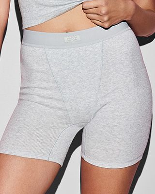 A MODEL POSES WEARING SKIMS BOXERS