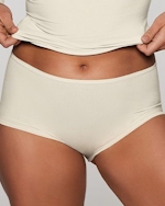 A MODEL POSES WEARING SKIMS BOY SHORTS