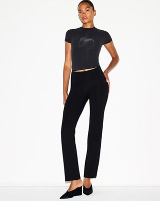 A MODEL POSES WEARING SKIMS LEGGINGS & PANTS