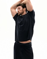 A MODEL POSES WEARING SKIMS MENS SPORT