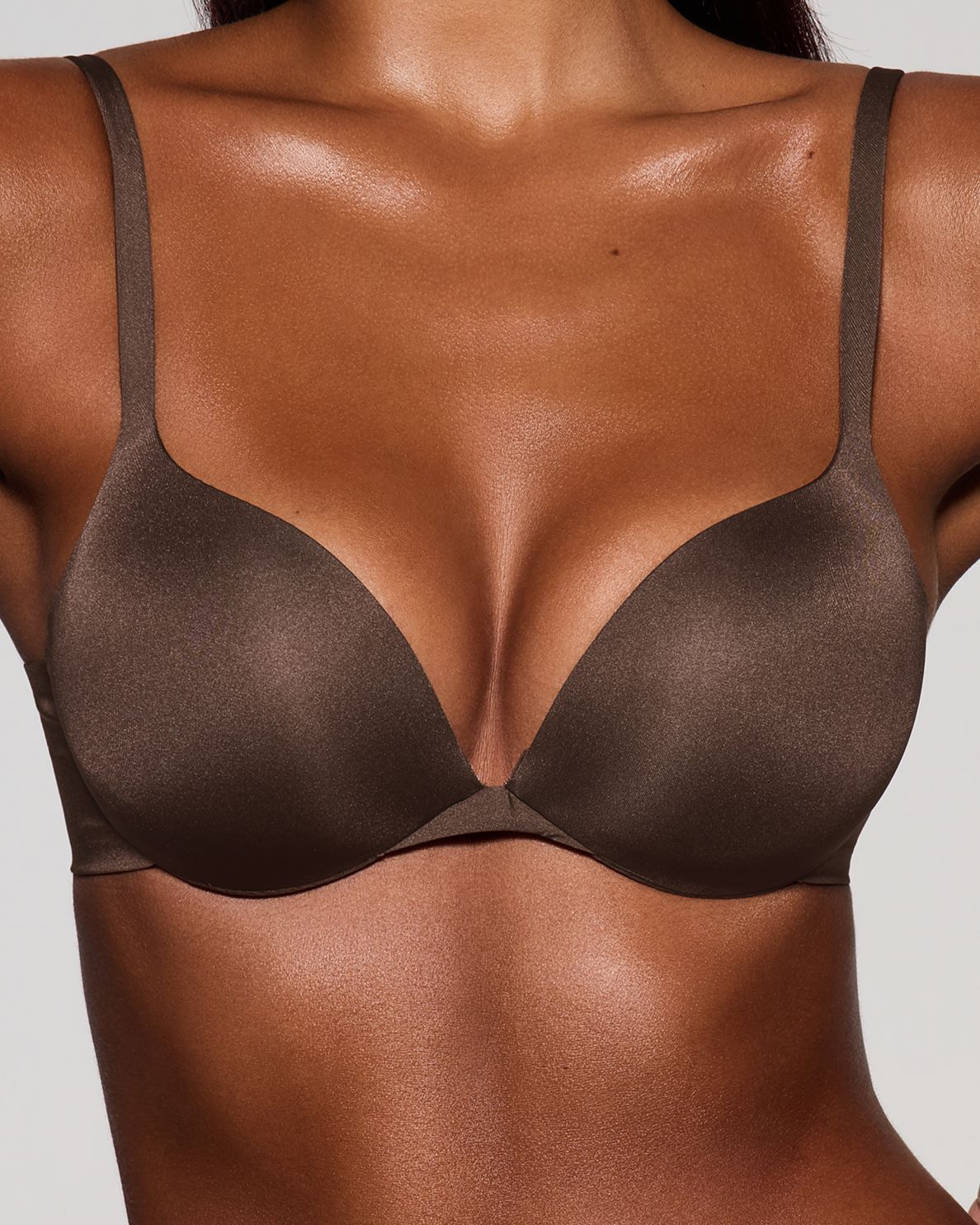 A model poses wearing SKIMS Ultimate Bra in cocoa
