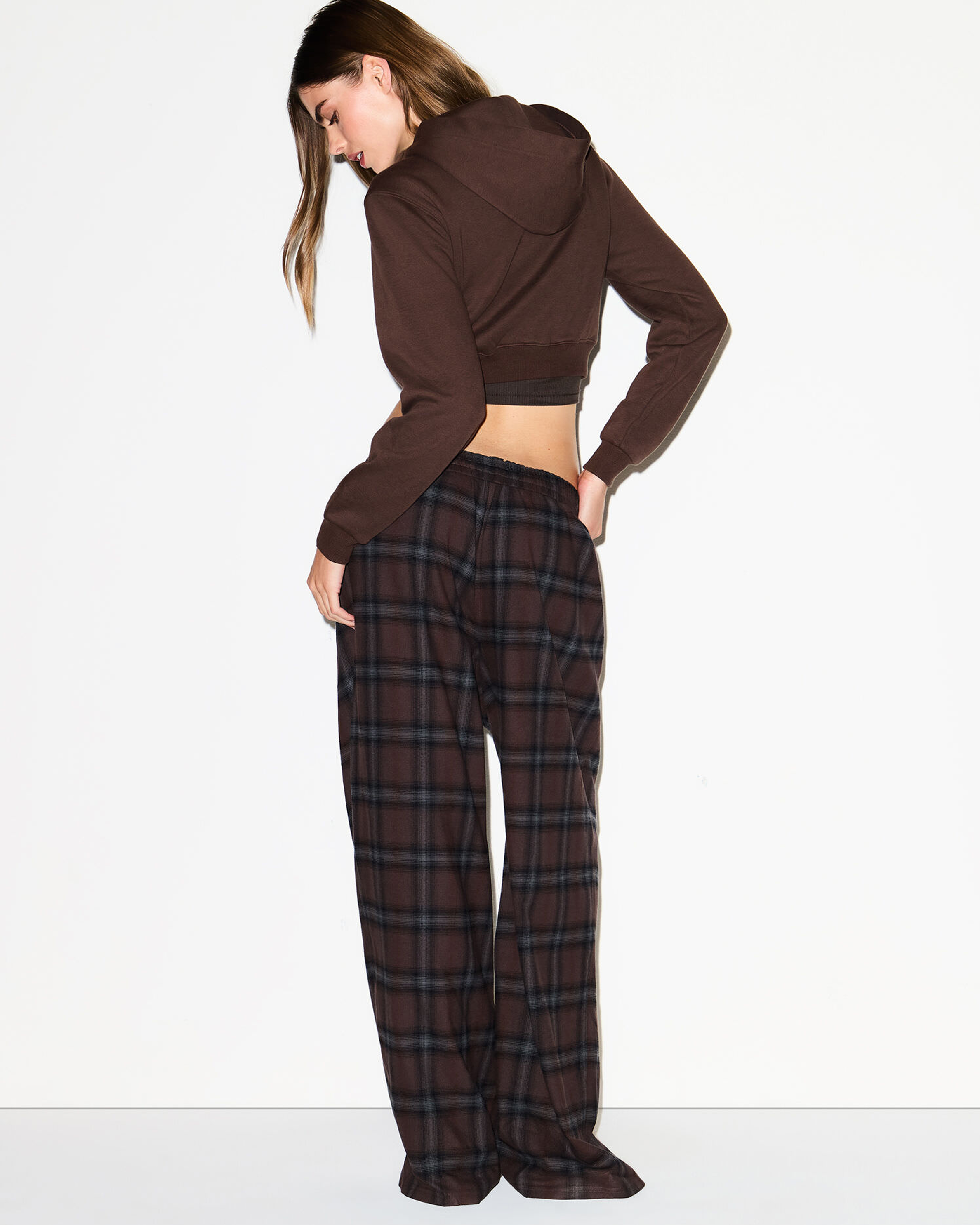 A MODEL POSES WEARING SKIMS LEGGINGS & PANTS