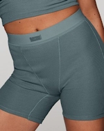 A MODEL POSES WEARING SKIMS BOXERS