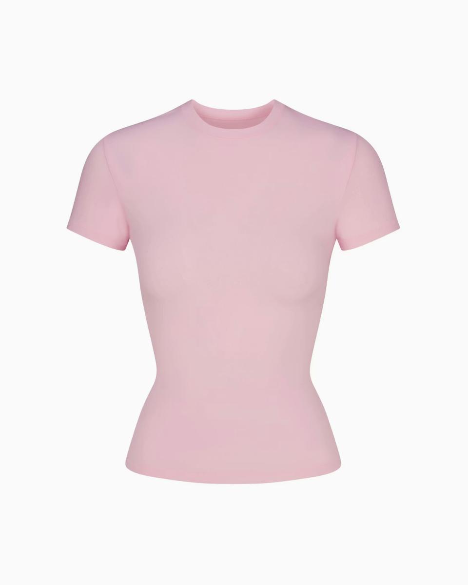 A MODEL POSES WEARING SKIMS COTTON T-SHIRT