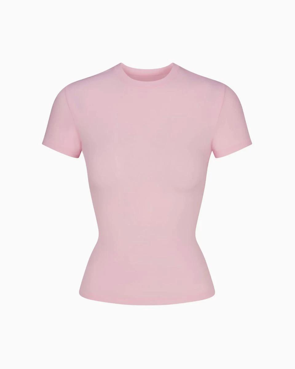 A MODEL POSES WEARING SKIMS COTTON T-SHIRT